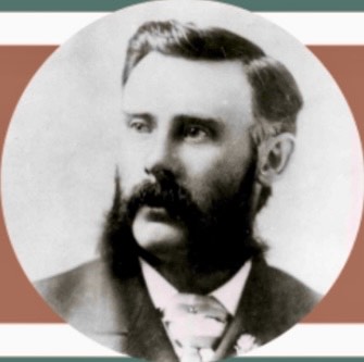 A historical, black and white photograph of a well dressed and groomed younger man, Ben Williams . The photograph encompasses his head to the start of his chest.
