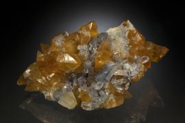 Celestine and calcite, Maybee, Monroe County, Michigan. Maybee produced some of the finest celestine specimens ever found in North America. This specimen is a particularly rare combination of celestine with golden calcite. Specimen 17 cm wide. Photo by J. Jaszczak and C. Stefano. (DM 25331)