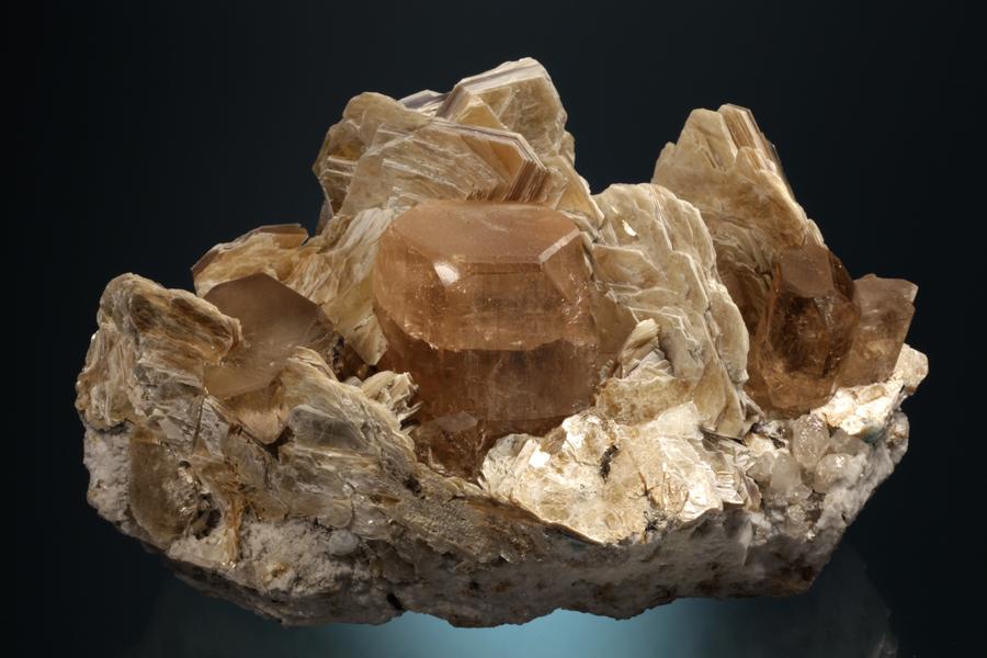 Topaz, Shigar Valley, Northern Pakistan. Sherry colored topaz crystals on pegmatite matrix with muscovite crystals. The pegmatite minerals of northern Pakistan are rapidly becoming modern classics. Donor: S. Meieran and F. Cirillo. Specimen 20 cm wide. Photo by C. Stefano. (DM 31199) 